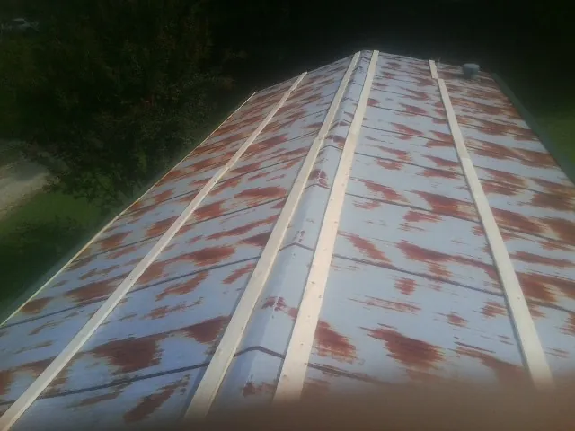 Rusted metal roof panels with new wood purlins before replacement — Storm Damage Roof Repair in Lancing by Roofing Brothers