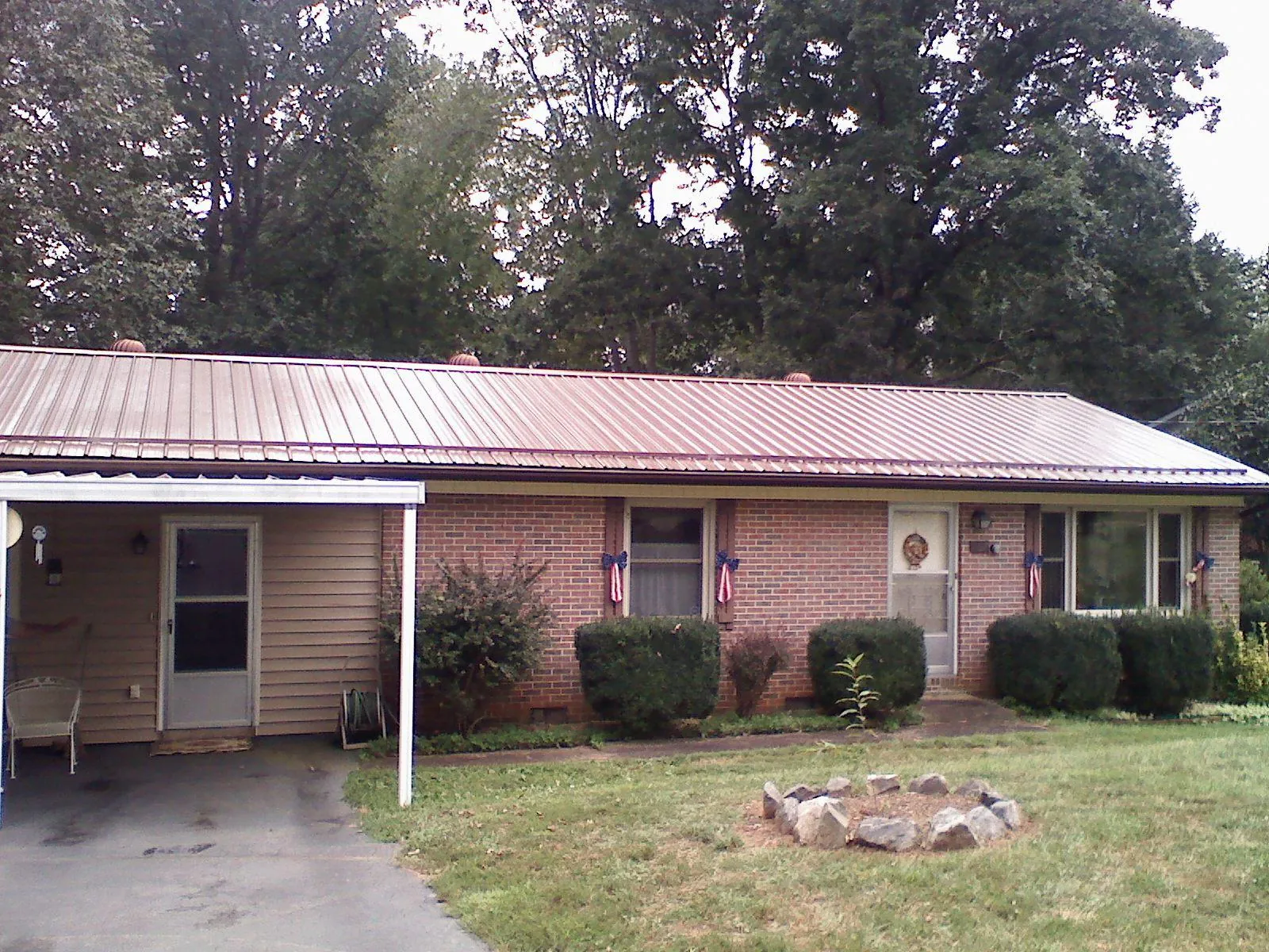 Bronze metal roof and carport on a brick ranch home — Roof Repair work by our crew in Lancing